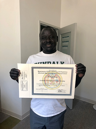 Bechak Deng holding certificate