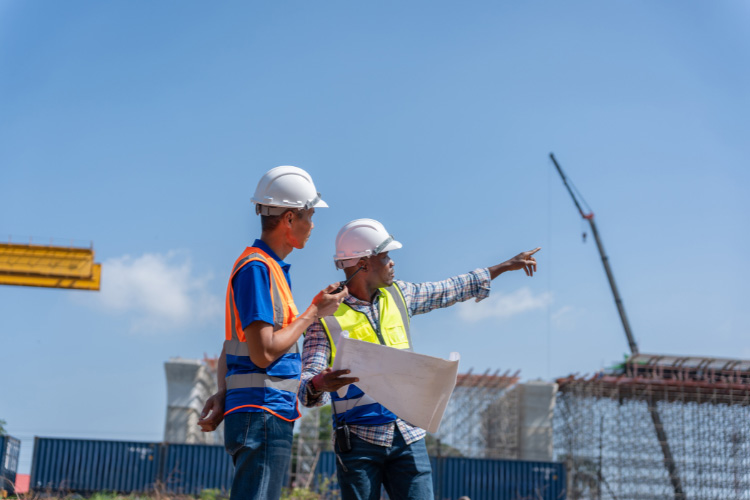 Two construction workers in hard hats and high-visibility vests