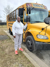 Tameka stands outside her school bus