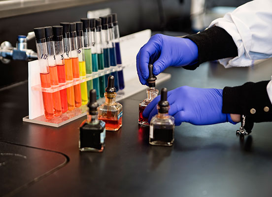 gloved hands handle test tubes