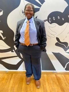Bethicia stands in business attire