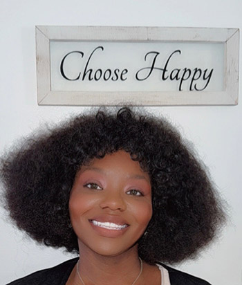 Mikia stands in front of a 'Choose Happy' sign